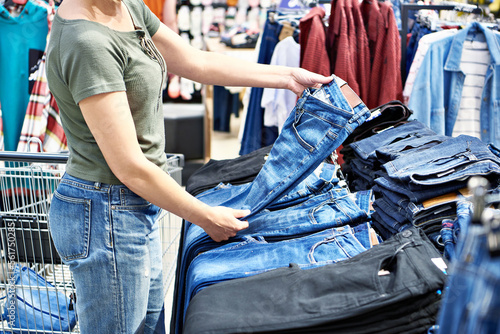 Buyer woman chooses jeans in store