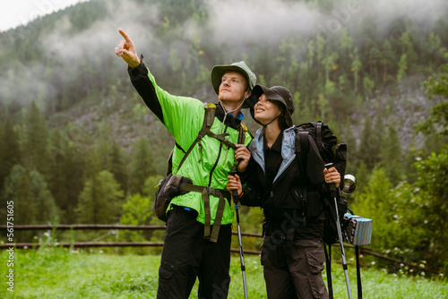 Young white people wearing trekking equipment hiking in mountain forest