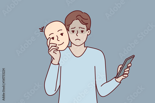 Unhappy man uses mask to pretend to be positive kind human during online dating and social media chat. Guy with phone remove face with smile after impersonating successful person. Flat vector design 