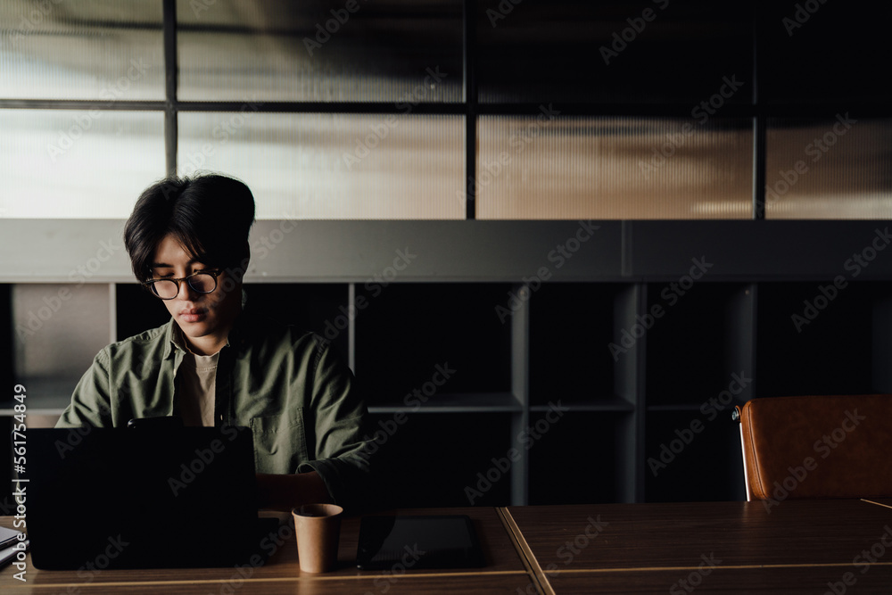 Young business man working on laptop while sitting in office Young business man working on laptop while sitting in office