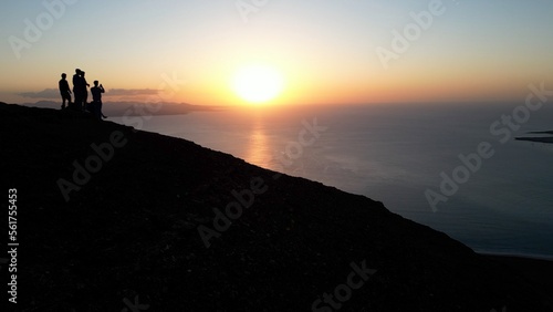 Spain, Lanzarote, Canary island - drone  view of people silhouette  on   amazing sunset in Mirador del Rio on the  Risco de Famara - Tourist looking the sun and the ocean sea - Travel in Lanzarote 