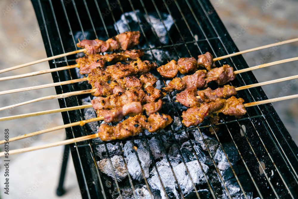 Lamb satay grilled above burnt charcoal.