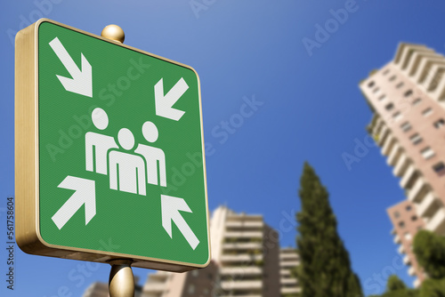 Emergency assembly point. Closeup of a green sign in a city against a clear blue sky. Outdoor sign indicating where people should congregate following an emergency evacuation of the building. photo