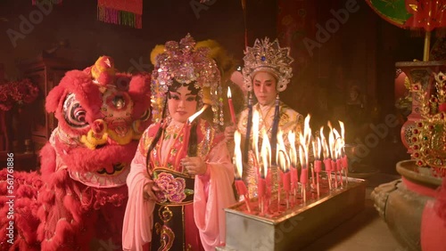 Male and female Chinese opera actors Light a candle to pray homage to the gods to enhance the prosperity for yourself on the occasion of the Chinese New Year festival. photo