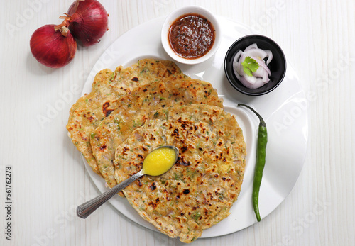 Indian traditional Hot Onion Paratha with tomato chutney. Indian onion stuffed Flatbread. also known as Pyaz ke parathe in Hindi. over a light background with copy space. photo