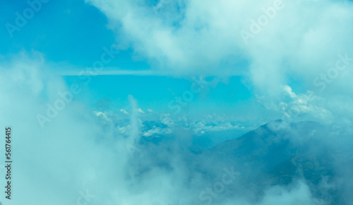 Bright panorama of the cloudy Andes Mountains from the Cerro las Nubes (Mount of the Clouds) in Jerico, Antioquia, Colombia. Very pale white and blue sky whith clouds and mist.
