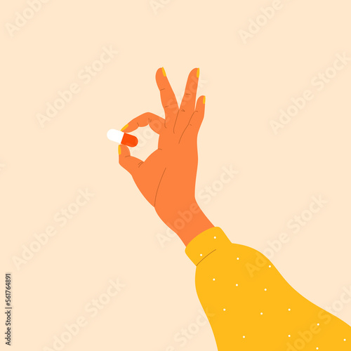 Woman's hand holding a pill