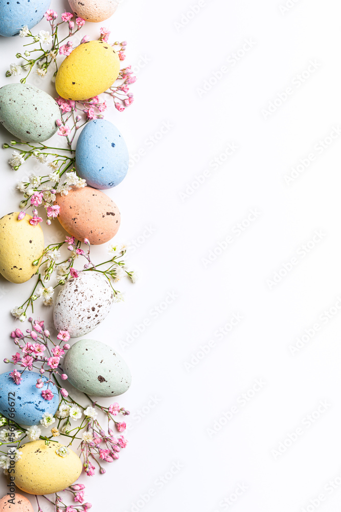 Easter quail eggs and springtime flowers over white background. Spring holidays concept with copy space. Top view Easter quail eggs and springtime flowers over white background. Spring holidays concept with copy space. Top view