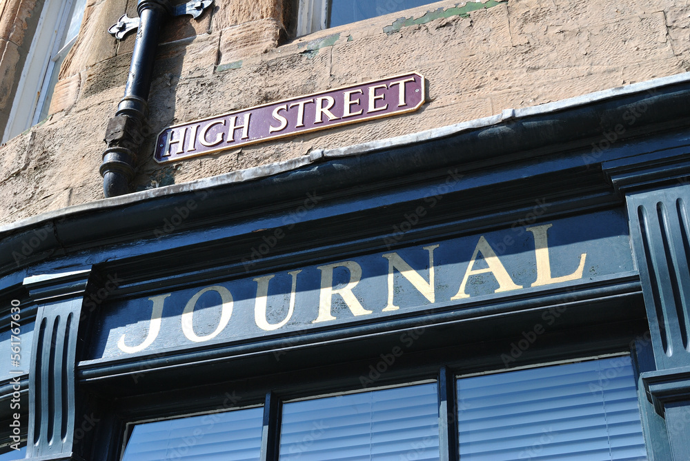 Old Shop Front on Old Stone Building with Signs 'High Street' and 'Journal' 
