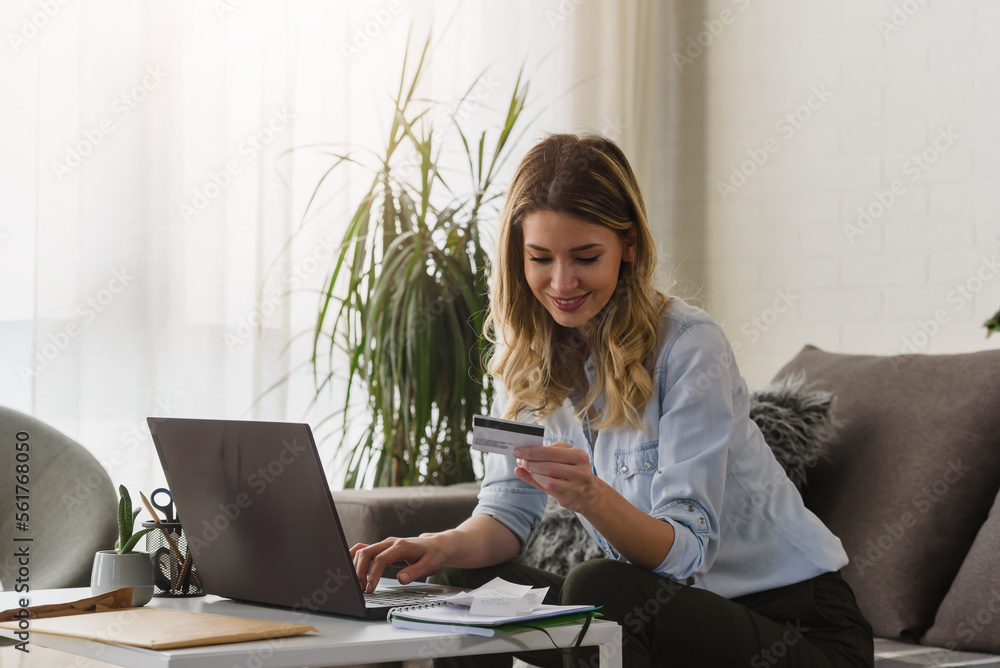 Young beautiful smiling woman paying making online payment with a credit card. Online banking. Young beautiful smiling woman paying making online payment with a credit card. Online banking.