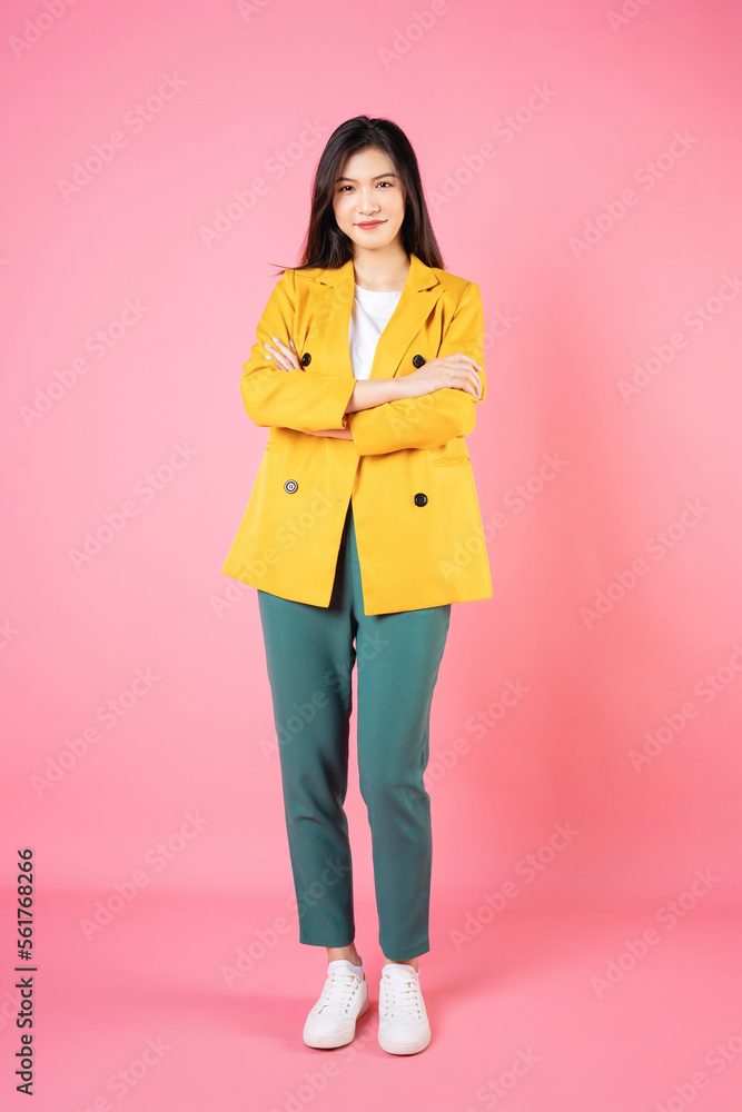 Full length image of young Asian business woman standing on background Full length image of young Asian business woman standing on background