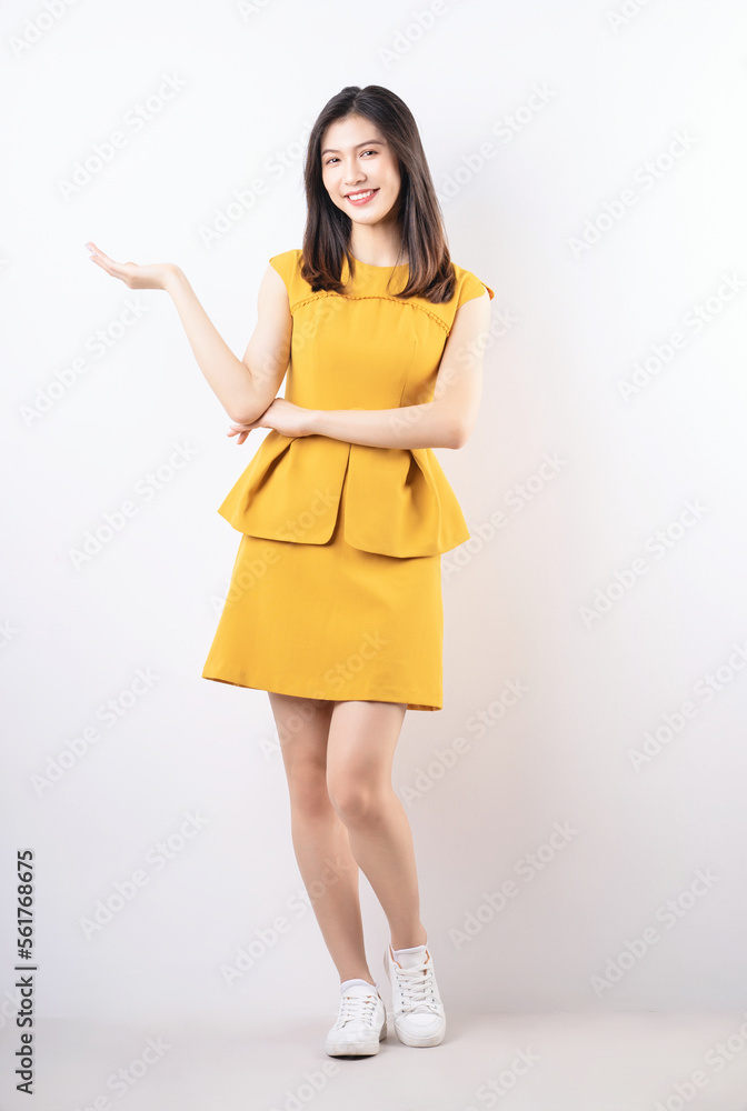 Full length photo of young Asian woman standing on white background Full length photo of young Asian woman standing on white background