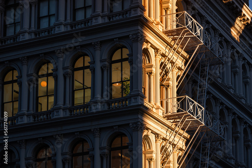 Last sun rays on Soho loft buildings with facade ornamentation and fire escape. Soho Cast Iron Building Historic District along lower Broadway, Lower Manhattan, New York City