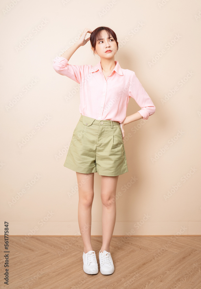 Full length photo of young Asian woman standing on background Full length photo of young Asian woman standing on background