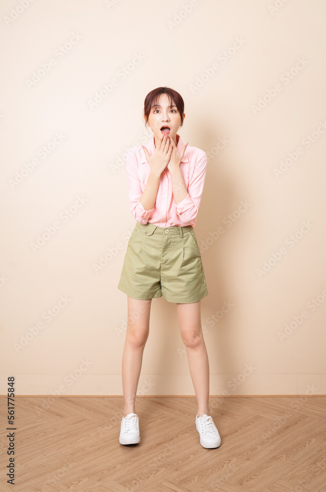 Full length photo of young Asian woman standing on background Full length photo of young Asian woman standing on background