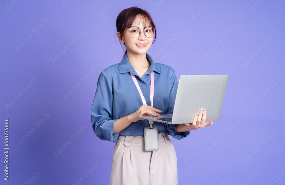 Photo of young Asian businesswoman holding laptop on background Photo of young Asian businesswoman holding laptop on background