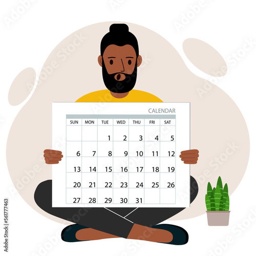 A man sits cross-legged and holds a large calendar glider in his hands. Concept of planning, make plans, schedule, event.