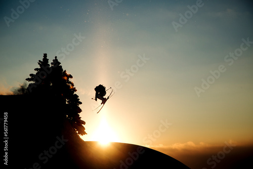 Silhouette of extreme skier in mid-air at sunset, Les Arcs, Bourg-Saint-Maurice, Savoie, France