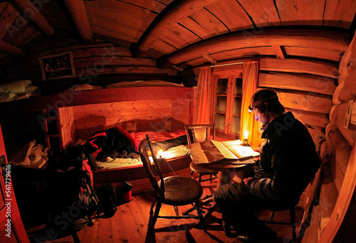 Man reading map in log cabin, Rondane National Park, Oppland County, Norway photo