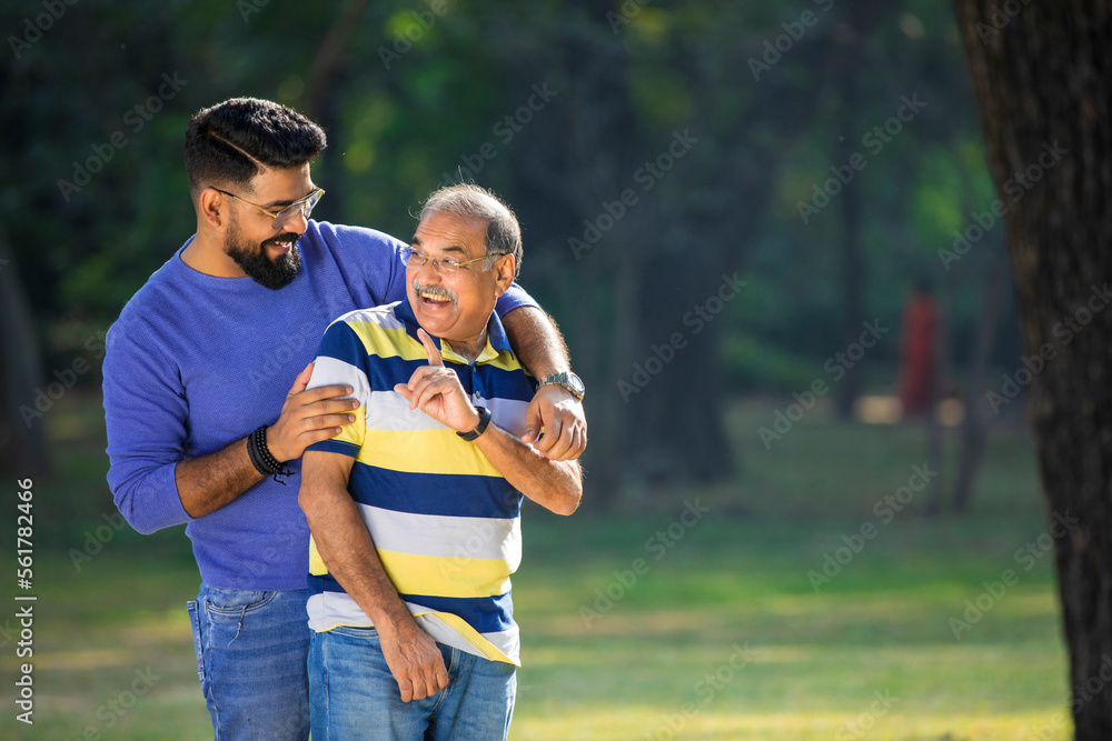 Fototapeta premium Old indian father with his young son spending time at park.