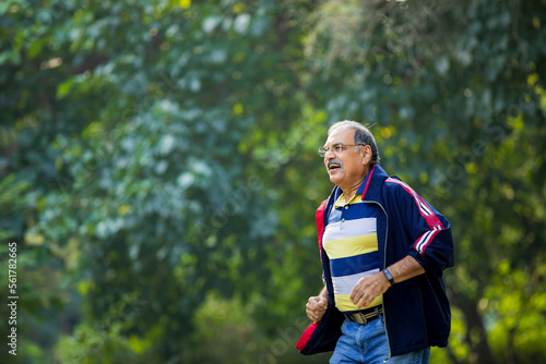Indian old man running or jogging at park © Niks Ads