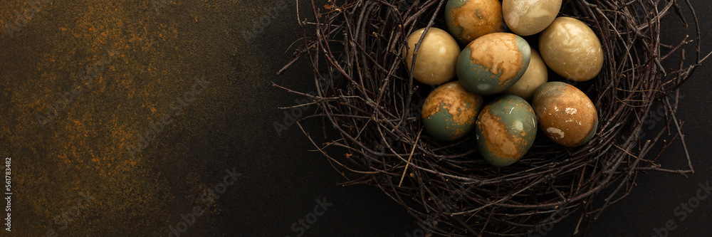 Obraz premium Cosmic Easter eggs in a nest on a brown background, top view, copy space, Easter banner