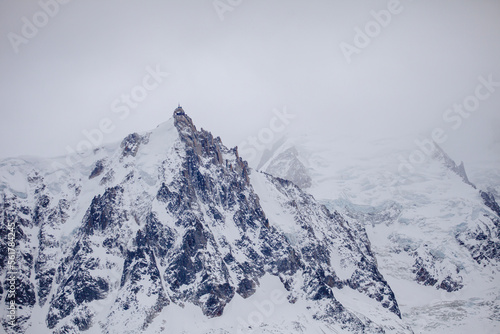 Foggy view of ridge of European Alps in winter, ski resort Chamonix Mont-Blanc, France. Ideal place for extreme sport and hiking. Winter activity. Natural background