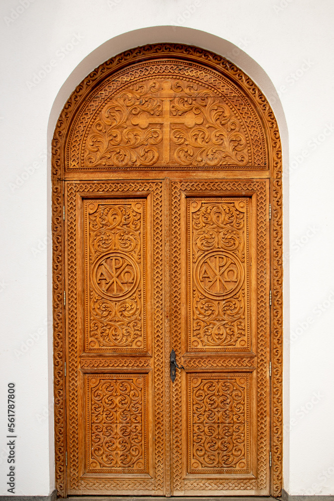 A wooden door with religious ornamental engravings at Dumbrava monastery - Romania