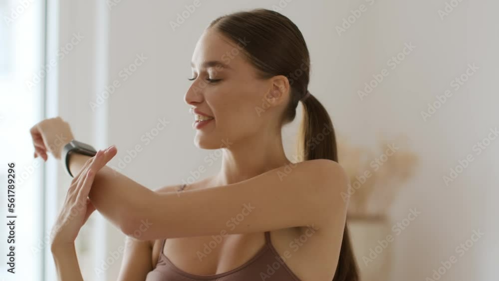 Body stretching before workout. Close up portrait of young happy woman warming up her muscles, twisting her wrist Body stretching before workout. Close up portrait of young happy woman warming up her muscles, twisting her wrist