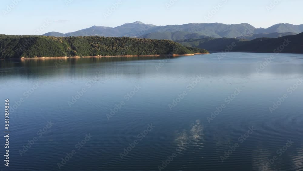 Flying low over a serene lake surrounded by mountains in Northern Macedonia Flying low over a serene lake surrounded by mountains in Northern Macedonia