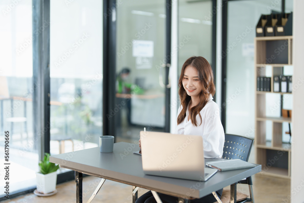 Portrait of a beautiful Asian teenage girl using computer for video conferencing at office Portrait of a beautiful Asian teenage girl using computer for video conferencing at office