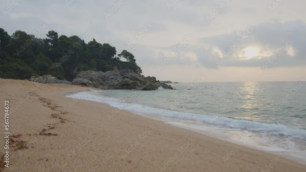 Steady shot at the edge of the wild beach at cloudy sunrise, in Spain Steady shot at the edge of the wild beach at cloudy sunrise, in Spain