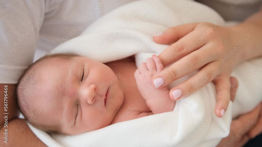 Closeup portrait of parents holding adorable newborn baby in their hands. Sweet family moments of mother, father and their sleeping infant child together Closeup portrait of parents holding adorable newborn baby in their hands. Sweet family moments of mother, father and their sleeping infant child together