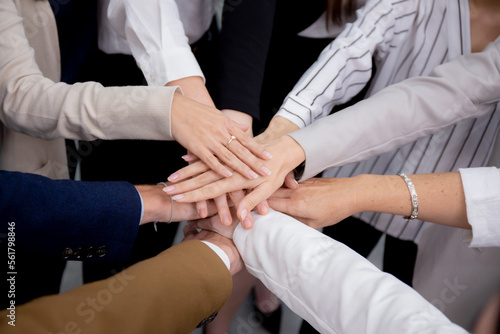 Group of business team harmonious with man and woman joining hands stack together in enterprise for victory and success, teamwork of partnership with meeting and cheering for achievement.