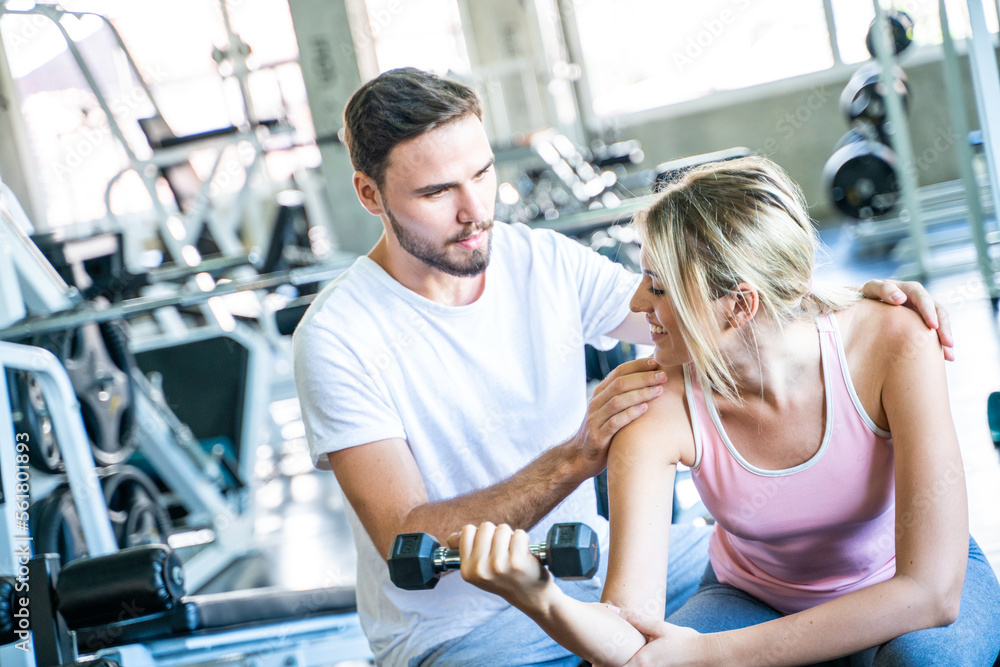 Sport man trainning woman exercise lifting weight in sport gym Sport man trainning woman exercise lifting weight in sport gym
