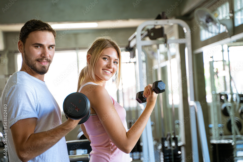 Fototapeta premium Sport man trainning woman exercise lifting weight in sport gym