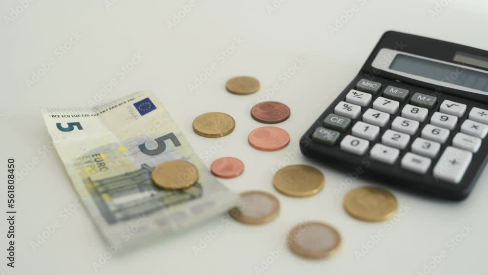 Calculator with money coins and banknote on table closeup. Finance operation and counting income Calculator with money coins and banknote on table closeup. Finance operation and counting income
