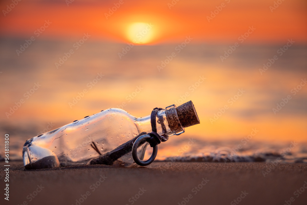 Message in the bottle against the Sun setting down - obrazy, fototapety, plakaty 