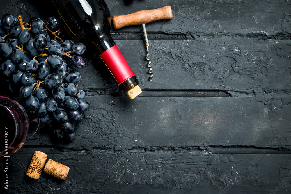 Wine background. Red wine with grapes and corkscrew.