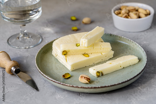 Φωτογραφία Italian cheese asiago with pistachios on stone black cutting board with cheese k