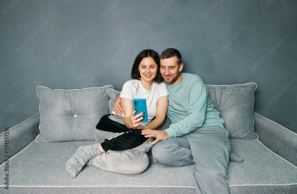 Young couple relaxing on sofa using mobile smart phone relaxing at home Young couple relaxing on sofa using mobile smart phone relaxing at home