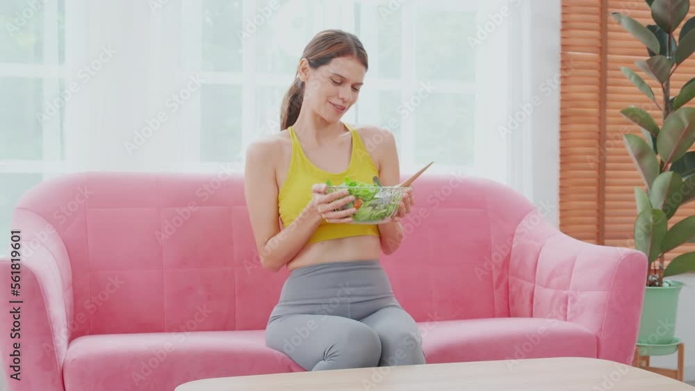 Happy young caucasian woman holding salad vegetable in bowl for eating lettuce in living room at home, female satisfied and vegetarian food for healthy and nutrition, lifestyles and health concept. Happy young caucasian woman holding salad vegetable in bowl for eating lettuce in living room at home, female satisfied and vegetarian food for healthy and nutrition, lifestyles and health concept.