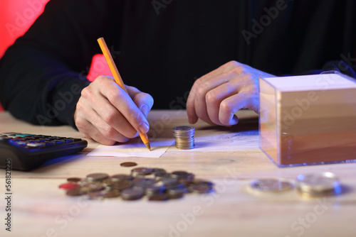 counting coins and writing a sum of money on a piece of paper by a person