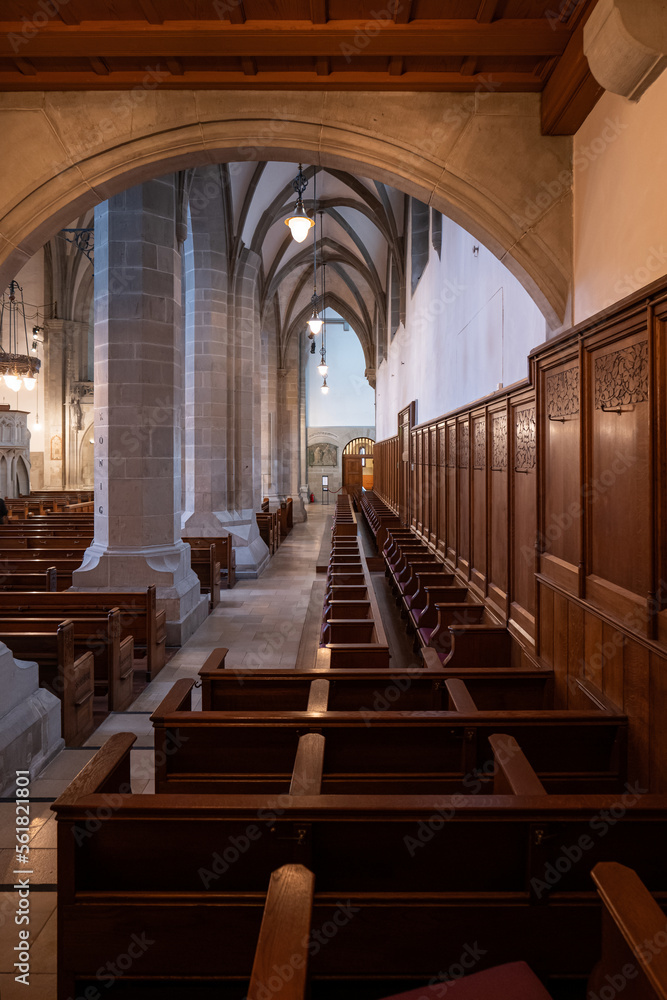Empty wooden pews or chairs inside Gothic, medieval church in Europe. Wide angle, no people