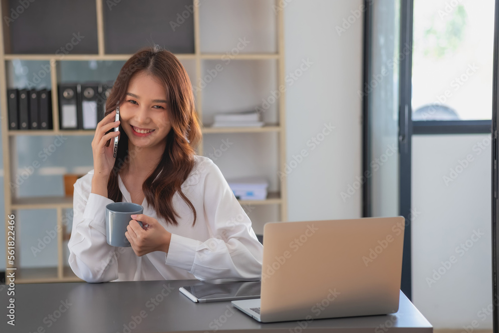Marketing, Financial, Accounting, Planning, businesswomen uses a mobile phone to contact a customer to inform her of the company is business partnership. Marketing, Financial, Accounting, Planning, businesswomen uses a mobile phone to contact a customer to inform her of the company is business partnership.