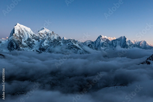 Mountain ridge in Himalayas at dusk. High peaks in cloud river in Nepal. © Eugene Ga