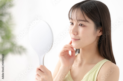 手鏡で顔を確認する女性 ビューティーイメージ
