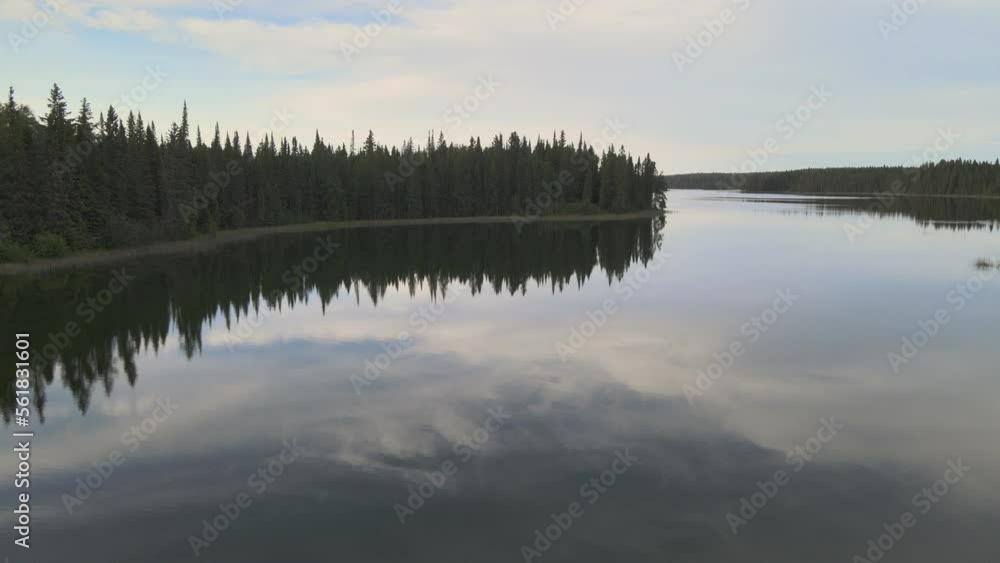 Moving slowly forward above a very calm northern lake with spruce trees along the shore. The calm water reflects the clouds.
Moving slowly forward above a very calm northern lake with spruce trees along the shore. The calm water reflects the clouds.