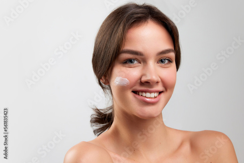 Portrait of beautiful happy young woman with smooth clear skin isolated over light studio background. Concept of natural beauty  skincare  cosmetology  health