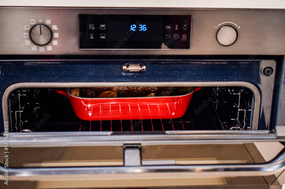 A partial view of a red refractory container inside the oven